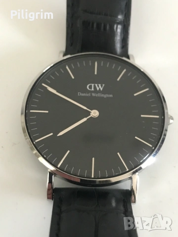 Часовник Daniel Wellington Classic Black със сребърен корпус и черна кожена каишка.