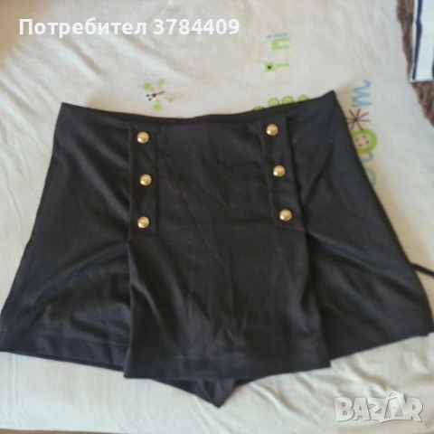 Черни дамски панталонки-пола с висока талия и декоративни златни копчета. ]