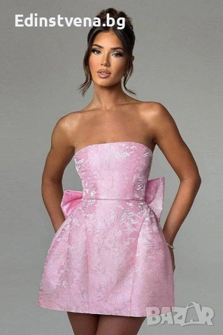 Дамска светлорозова мини рокля без презрамки с флорален релеф и голяма панделка на гърба