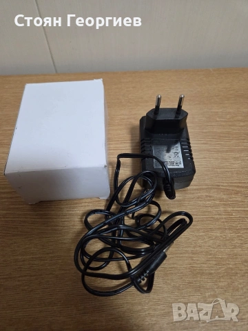 захранващ адаптер (зарядно устройство) с изходно напрежение 12V и ток 1000mA (1A).