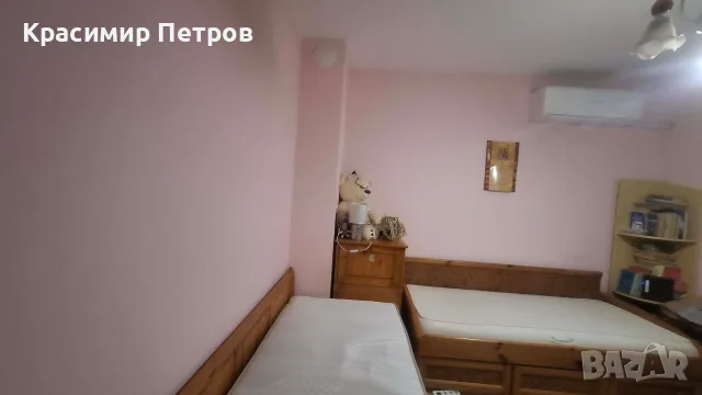 Единични легла от естествена дървесина с матраци и ракла.