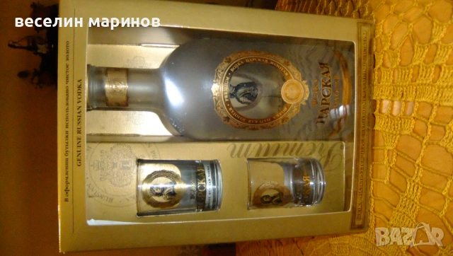 Продавам опзлатена стъклена бутилка от водка с две чаши за водка