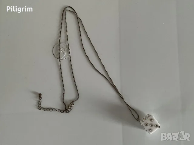 Стилно сребърно колие с висулка във формата на зарче.